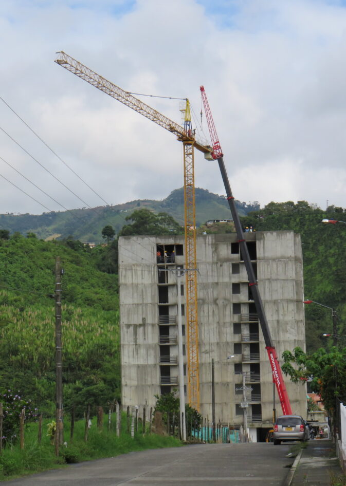 Grúa torre y grúa móvil junto a un edificio en construcción en Colombia Grúa torre y grúa móvil junto a un edificio en construcción en Colombia